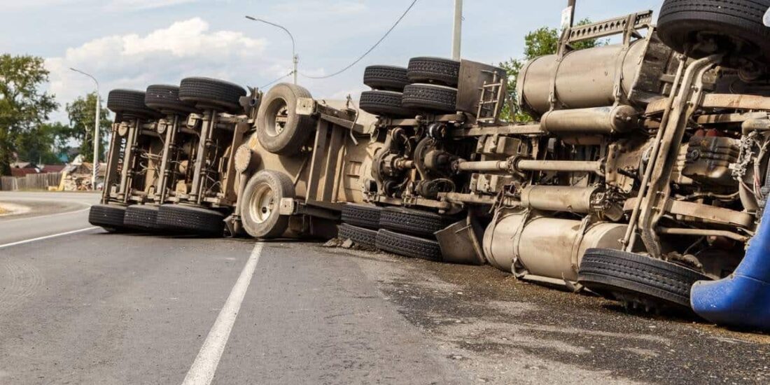 Overturned commercial truck on highway demonstrating the serious consequences involved in truck accident liability cases and the importance of proper legal representation